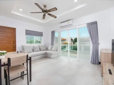 a living room with a couch and a ceiling fan at 1 bedroom apartment in Nai Harn in Ban Saiyuan (1)