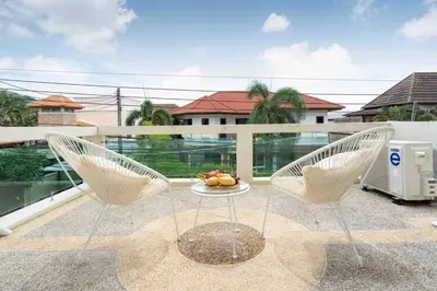 a balcony with two chairs and a table with fruit on it at 1 bedroom apartment in Nai Harn in Ban Saiyuan (1)