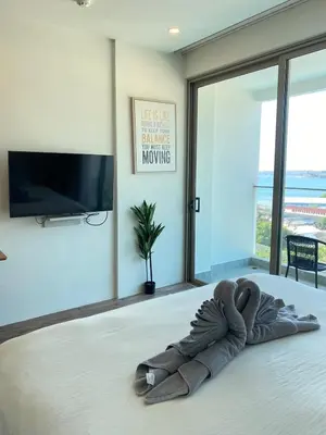 a stuffed animal laying on a bed in a room at OCEANA HOME Phuket Kamala in Kamala Beach