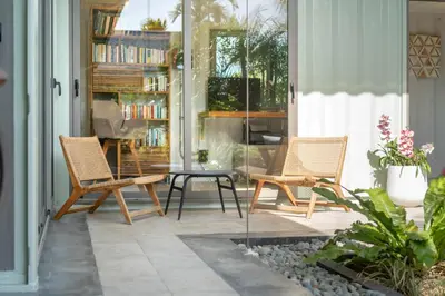 a patio with two chairs and a table on a porch at Contemporary Eden - Villa Jeladore, 5BR, Garden & Pool, near Laguna in Bang Tao Beach