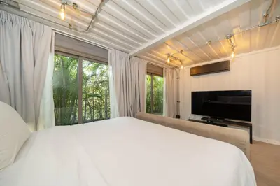 a bedroom with a white bed and a large window at Contemporary Eden - Villa Jeladore, 5BR, Garden & Pool, near Laguna in Bang Tao Beach