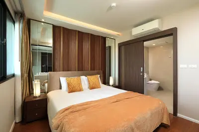 a bedroom with a large bed and a bathroom at 3bdr Sea View Apartment Surin Beach by Capital Pro in Phuket Town