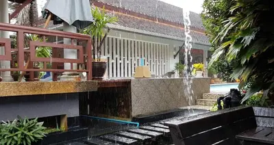a water fountain in front of a house at Plumeria Villa Thalang in Ban Pak Lak