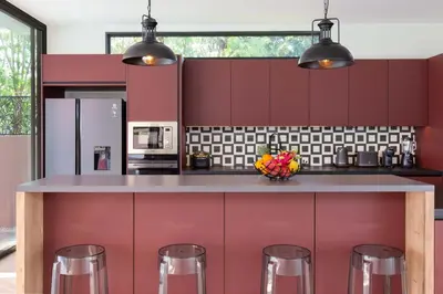 a kitchen with red cabinets and a counter with stools at Brand-new 8BR Private Pool Villa Mystic Garden in Rawai Beach