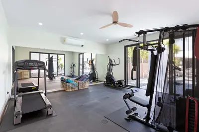 a gym with several tread machines in a room at Brand-new 8BR Private Pool Villa Mystic Garden in Rawai Beach