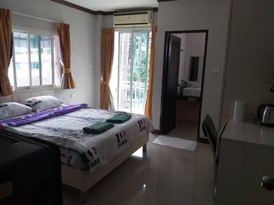 a bedroom with a bed and a large window at Elba Bella Guest House in Patong Beach