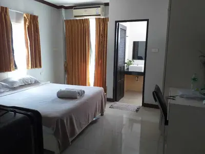 a bedroom with a bed and a mirror and a sink at Elba Bella Guest House in Patong Beach