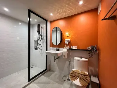 a bathroom with a toilet and a sink and a mirror at Sierra Hostel in Nai Yang Beach