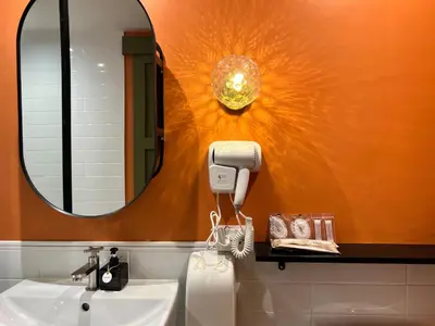 a bathroom with a sink and a mirror at Sierra Hostel in Nai Yang Beach