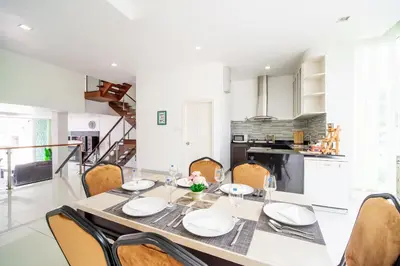 a dining room table and chairs in a kitchen at \u82ad\u4e1cVilla2:\u56db\u5367\u6d77\u666f\u522b\u5885 \u53cc\u6d77\u666f \u4e2d\u82f1\u6cf0\u4e09\u6587\u7ba1\u5bb6 in Patong Beach
