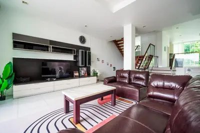 a living room with a leather couch and a table at \u82ad\u4e1cVilla2:\u56db\u5367\u6d77\u666f\u522b\u5885 \u53cc\u6d77\u666f \u4e2d\u82f1\u6cf0\u4e09\u6587\u7ba1\u5bb6 in Patong Beach