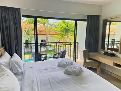 a bedroom with a bed with two towels on it at Estella Phuket Mai Khao Beach Resort in Mai Khao Beach
