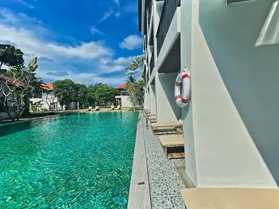 a swimming pool next to a building with a life preserver at Estella Phuket Mai Khao Beach Resort in Mai Khao Beach