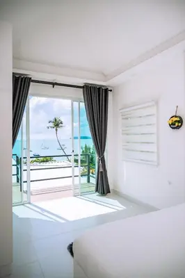 a white room with a view of the ocean at Mr Oh's Seaview House Phuket AoYon in Phuket Town
