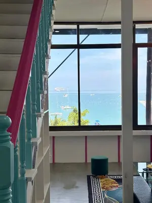 a room with a large window with a view of the ocean at Mr Oh's Seaview House Phuket AoYon in Phuket Town