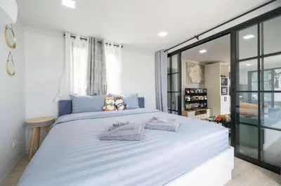 a bedroom with a large white bed with towels on it at Mr Oh's Seaview House Phuket AoYon in Phuket Town