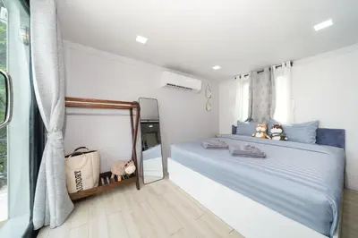 a bedroom with a blue bed and a mirror at Mr Oh's Seaview House Phuket AoYon in Phuket Town