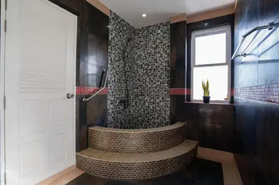 a bathroom with a tub and a shower with a window at Patong Blue House Panorama View in Patong Beach