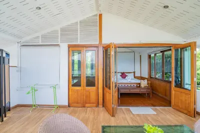a room with wooden doors and a bed at Patong Blue House Panorama View in Patong Beach