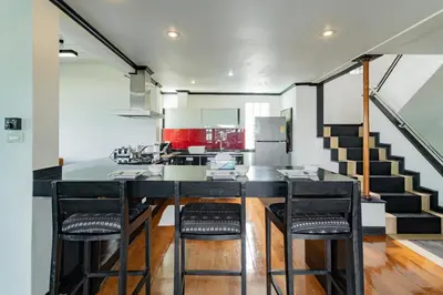 a kitchen with a counter and stools in a room at Patong Blue House Panorama View in Patong Beach