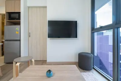 a living room with a television and a table and a chair at SkyPark , Bangtao , Apartment near beach 2 bedroom in Bang Tao Beach