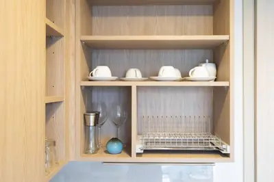 a cupboard with bowls and plates and a blender at SkyPark , Bangtao , Apartment near beach 2 bedroom in Bang Tao Beach