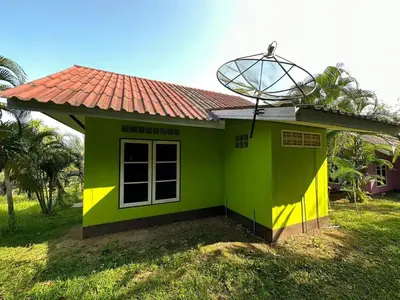 a small green and yellow house with a red roof at Baansuanpiyanan in Ban Bang Chak