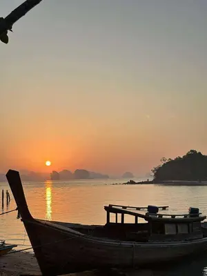 a boat sitting on the beach at sunset at Baansuanpiyanan in Ban Bang Chak