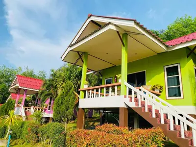 a green house with a white staircase in front of it at Baansuanpiyanan in Ban Bang Chak