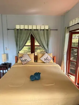 a large bed with a blue flower on top of it at Baansuanpiyanan in Ban Bang Chak