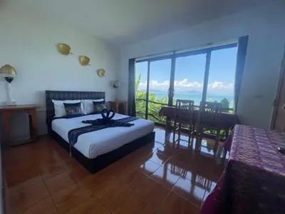 a bedroom with a bed and a view of the ocean at Phu Samut in Ban Ba Kan Pa