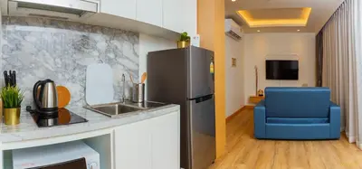 a kitchen with a refrigerator and a blue chair at Aristo 2 Apartments by Beringela in Surin Beach