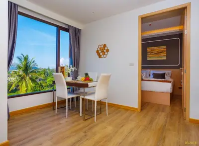 a dining room with a table and chairs and a bedroom at Aristo 2 Apartments by Beringela in Surin Beach
