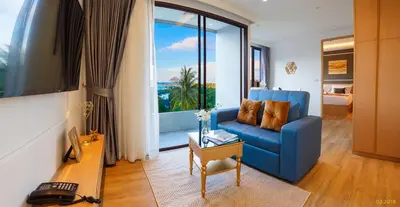 a living room with a blue couch and a large window at Aristo 2 Apartments by Beringela in Surin Beach