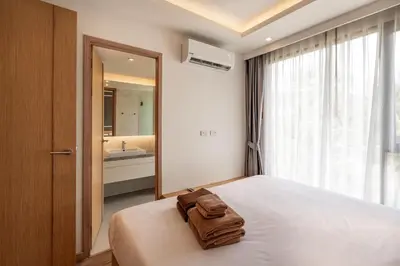 a bedroom with a bed and a large mirror at Aristo 2 Apartments by Beringela in Surin Beach