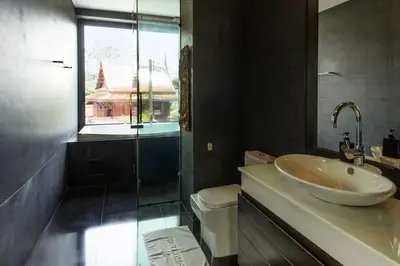 a bathroom with a sink and a glass shower at Attractive SeaView 4br Private Pool Villa in Rawai Beach