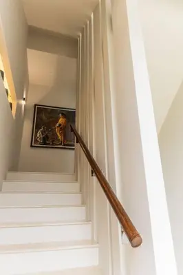 a staircase with a wooden rail in a stair case at Attractive SeaView 4br Private Pool Villa in Rawai Beach