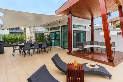 an outdoor patio with a table and chairs at Attractive SeaView 4br Private Pool Villa in Rawai Beach