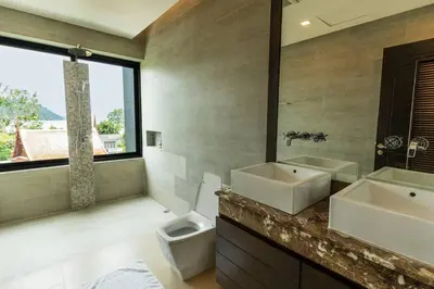 a bathroom with two sinks and a toilet and a window at Attractive SeaView 4br Private Pool Villa in Rawai Beach