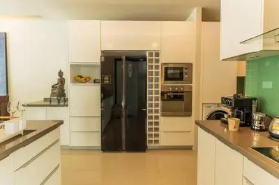 a large kitchen with a black refrigerator and appliances at Attractive SeaView 4br Private Pool Villa in Rawai Beach