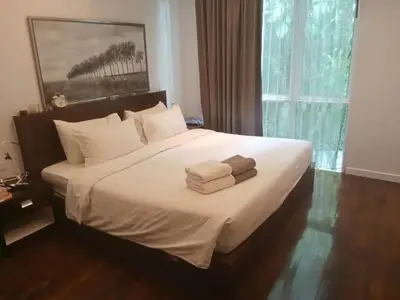 a bedroom with a large bed with towels on it at Tropical 1bedroom Apartment in Kamala Beach