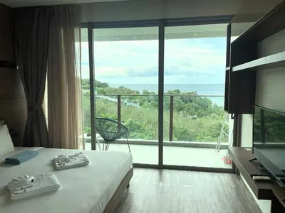 a hotel room with a bed and a large window at Sea view apartment at Oceana by Lofty in Kamala Beach