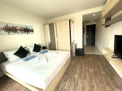 a bedroom with a large white bed and a flat screen tv at Sea view apartment at Oceana by Lofty in Kamala Beach