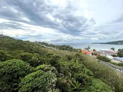 a view of the ocean from a hill with trees at Sea view apartment at Oceana by Lofty in Kamala Beach