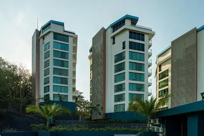 two tall buildings with palm trees in front of them at Sea view apartment at Oceana by Lofty in Kamala Beach