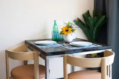 a dining room table with two chairs and a table with plates at Woodbridge Property at Karon Butterfly in Karon Beach
