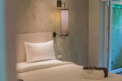a bedroom with a bed with a white pillow and a lamp at Woodbridge Property at Karon Butterfly in Karon Beach