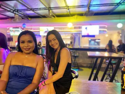 two young women sitting at a table in a bar at Kana Hotel Phuket\u666e\u5409\u5c9b\u5361\u5a1c\u9152\u5e97 in Rawai Beach