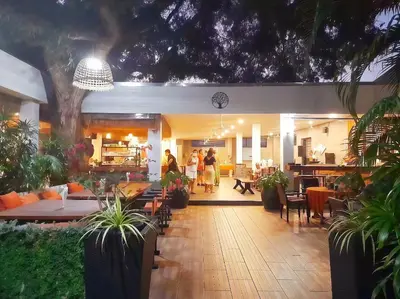 a group of people walking around a restaurant with tables and chairs at Kana Hotel Phuket\u666e\u5409\u5c9b\u5361\u5a1c\u9152\u5e97 in Rawai Beach