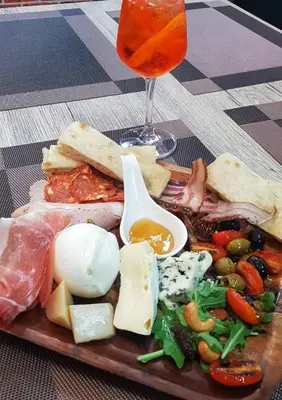 a plate of food with meat and cheese and a drink at Lo Sfizio in Patong Beach